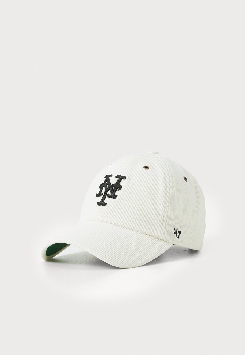 Valge korduroy beanie, millel on must tikandiga logo. Sellel on kõveräni ja õhutusaugud, detailiks roheline aluspind.