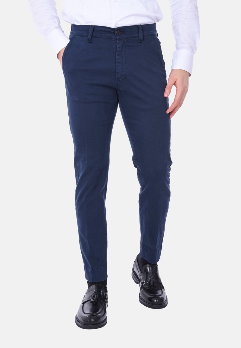 Chinos in cotone blu navy con una vestibilità slim, dotati di chiusura con bottone, tasche frontali e una texture liscia. Abbinati a scarpe nere.