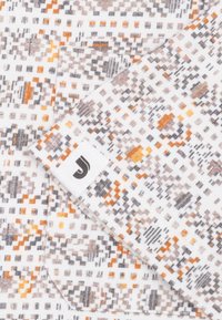 Textiel met een witte basis en een geometrisch patroon in oranje, grijs en zwart. Inclusief een label met een gestileerde "J" logo.