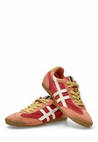 Zapatillas de ante rojo y malla con rayas blancas, cordones amarillos y suela de goma marrón. Presentan un respaldo acanalado y detalles a rayas.