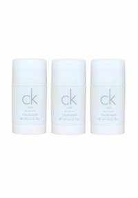 Kolme valkoista tikku deodoranttia, joilla on sileä pinta. Jokaisessa on vaaleanharmaalla painettuna "ck one" ja "CALVIN KLEIN". Nettopaino 75 g (2,6 oz).