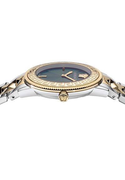 Versace kell sinise diali, kuldse äärisega, mis sisaldab Kreeka võtme mustrit, hõbedaste linkidega rihma, lõvikoosluse embleemiga kroonit ja minimalistlikke näpu.