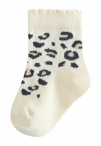 Cream-colored sock with black and beige leopard print, ribbed top edge, textured weave, and a comfortable ankle length design.