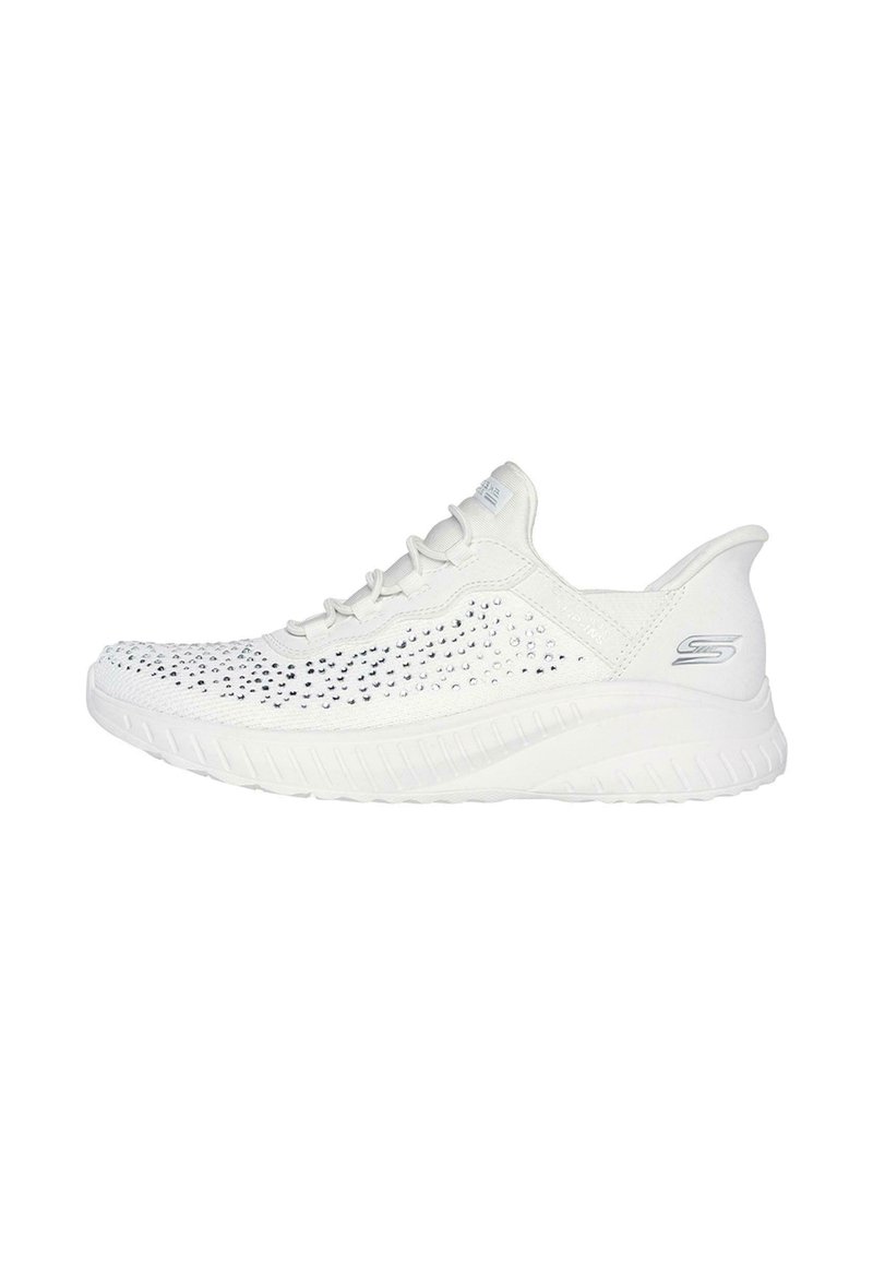Zapatillas deportivas blancas con parte superior texturizada que presenta pequeños perforados y detalles de pedrería, talón curvado y suela acolchada.