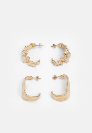 Quatre paires de boucles d'oreilles en or : une créole texturée en forme de vagues, une créole lisse en forme de croissant, toutes deux avec des fermetures à tige.