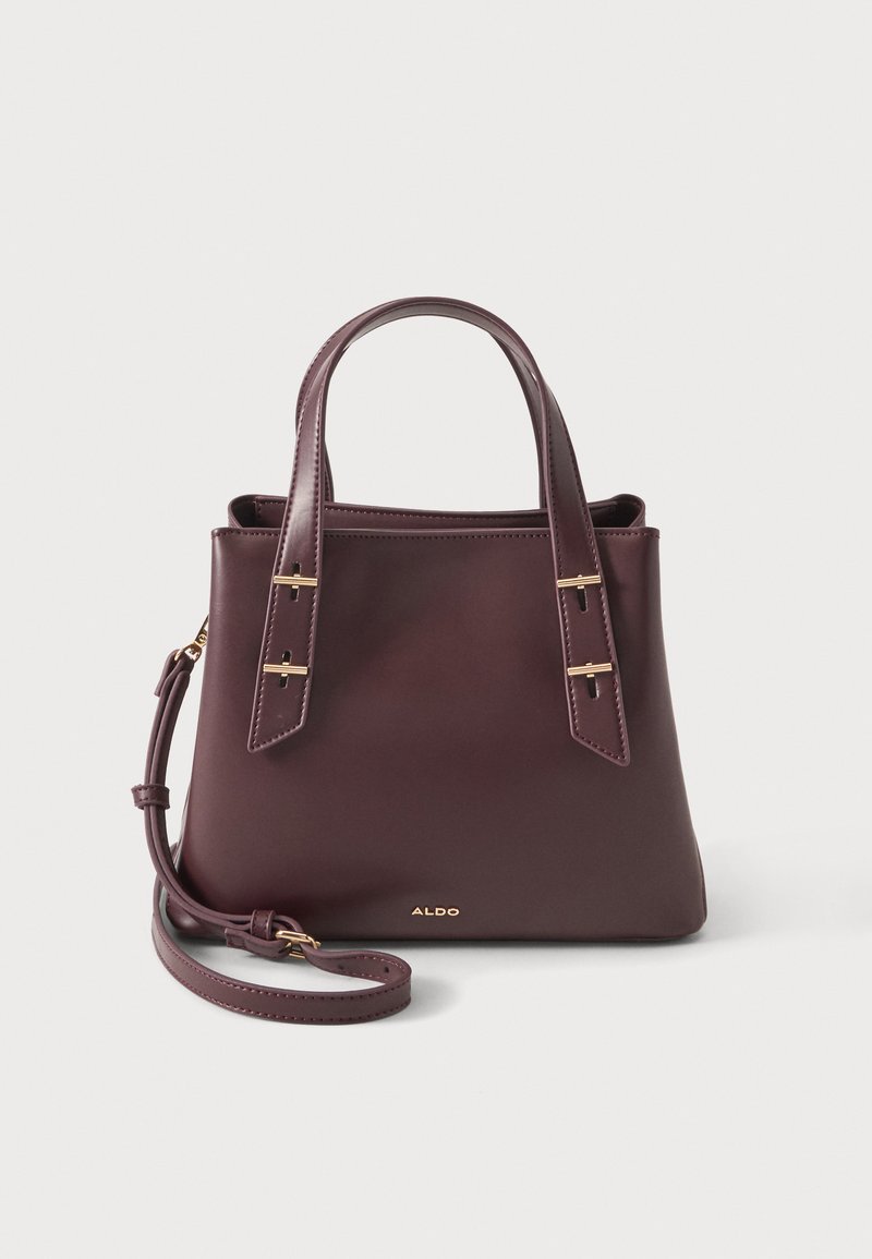 Sac à main en cuir brun foncé avec deux poignées supérieures, une bandoulière amovible et des ferrures dorées sur fond blanc.