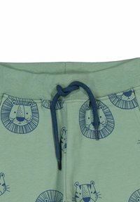 Gröna bomullsshorts med ett alltigenom lion tryck i marinblått. Elastisk midja med en matchande dragsko. Slät textur.