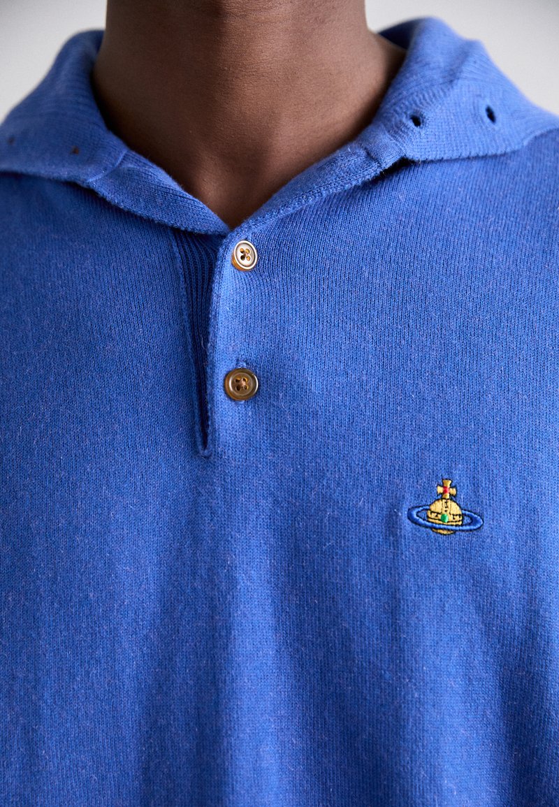 Blauwe gebreide poloshirt met een capuchon, een twee knoopsluiting en een geborduurd ontwerp van een schip binnen een ring op de linkerborst.