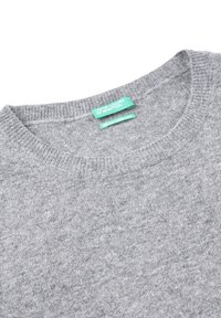 Jasnoszary sweter dziewiarski z dekoltem, posiadający dwie zielone metki z napisem "United Colors of Benetton" oraz "Wełna merino z Włoch".