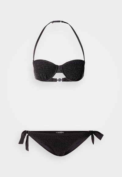 Črni bikini komplet z zgornjim delom bandeau s teksturiranim, nabranim materialom, ki ima oprtnike za vrat, in spodnjim delom z zavezovanjem na strani. Preprosta zasnova z minimalnimi kovinskimi dodatki.