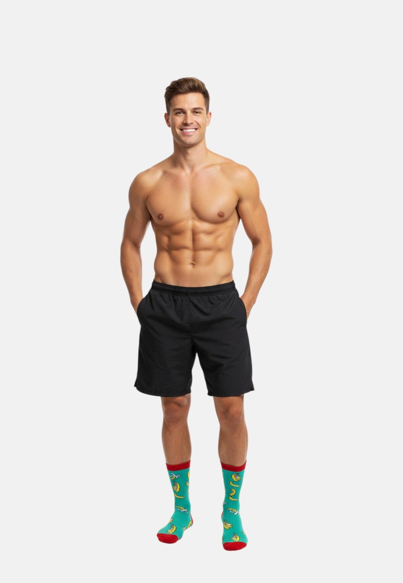 Sorte shorts med elastisk talje, parret med turkise sokker med gule bananmønstre og røde accenter.