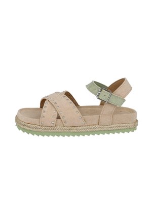 Sandalias de ante beig con tiras cruzadas, tachuelas plateadas y una hebilla verde ajustable. Cuentan con una suela de cuerda natural y textura verde.
