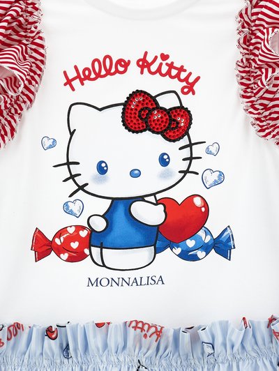 Η καρτούν Hello Kitty κρατά μια κόκκινη καρδιά, περιτριγυρισμένη από μπλε καρδιές και σχήματα καραμέλας, με κόκκινες ριγωτές πιέτες στα μανίκια σε λευκό ύφασμα.