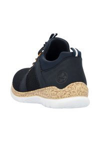 Baskets navy avec des panneaux en mesh, semelle en caoutchouc à texture de liège et accents jaunes contrastants. Le design comprend un logo sur le talon.