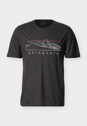 Tummanharmaa lyhythihainen t-paita, jossa monivärinen vuoristokuvio ja "patagonia"-teksti keskellä edessä.