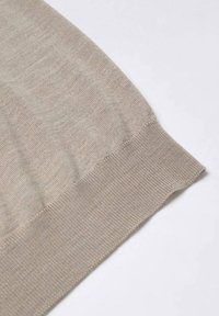 Hellbeige gestrickter Pullover mit detaillierter Textur im Körper und gerippten Bündchen, der ein glattes, weiches Material und saubere Kanten hervorhebt.