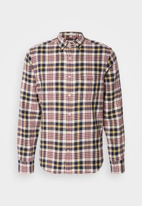 Chemise à manches longues boutonnée avec col, présentant un motif à carreaux rouge, bleu marine, jaune et blanc, avec une poche poitrine.