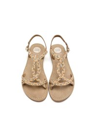 Sandalias color marrón con tiras trenzadas que presentan un patrón decorativo. Suela plana con un borde cosido, hebilla en el tobillo ajustable para un buen ajuste.