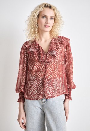 Blusa rossa e crema con motivo a fantasia, colletto arricciato, maniche lunghe e polsini elastici, realizzata in tessuto leggero; chiusura anteriore con bottoni.