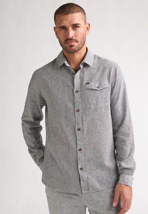 Overhemd met knoopsluiting van gestreepte grijs-witte stof, voorzien van een borstzak, bruine knopen en lange mouwen met manchetdetail.