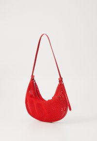 Sac à main en maille rouge de forme incurvée, doté d'une fermeture éclair et d'une bandoulière simple. La texture est en tissage ouvert, légère et flexible.