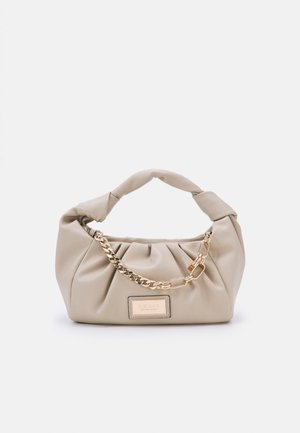 Sac à main beige doux froncé avec une poignée torsadée, un accent en chaîne dorée et une petite étiquette de marque à l'avant.