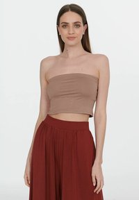 Jasnobrązowy strapless crop top wykonany z gładkiego materiału, po�łączony z wysokim stanem bordowymi spodniami w plisy. Prosty design, bez wzorów.
