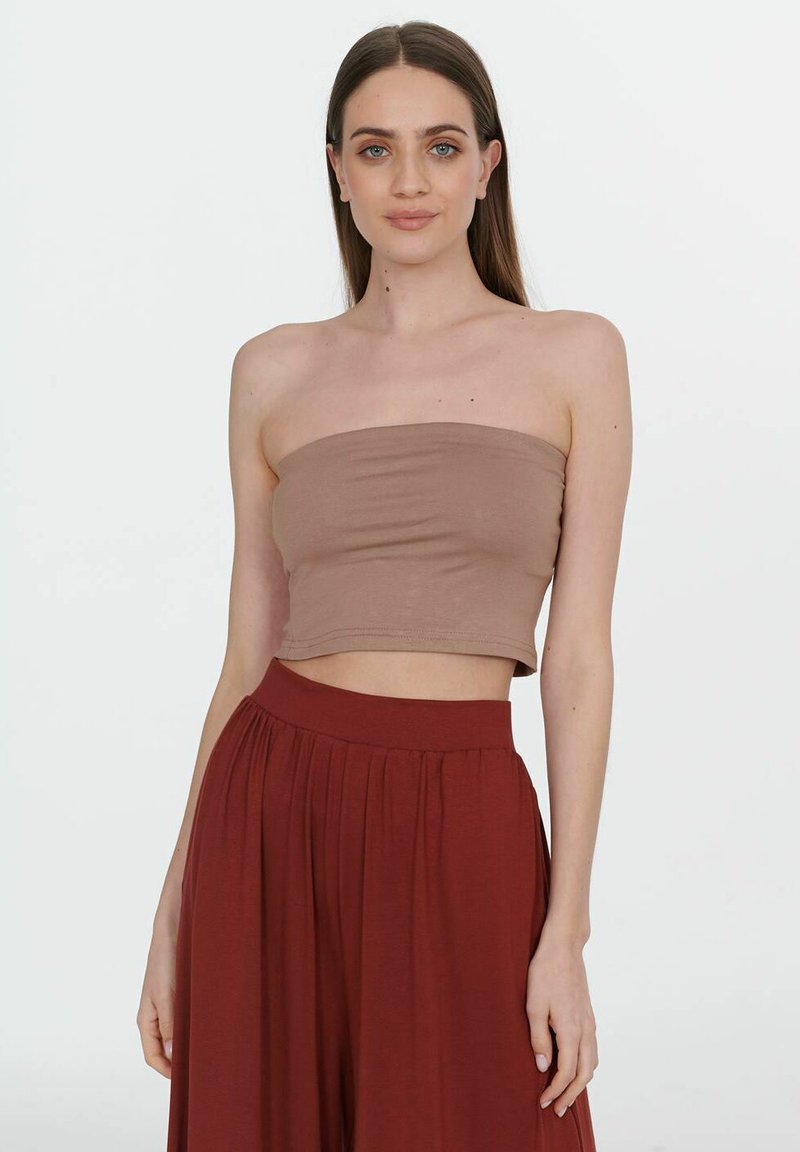 Jasnobrązowy strapless crop top wykonany z gładkiego materiału, połączony z wysokim stanem bordowymi spodniami w plisy. Prosty design, bez wzorów.