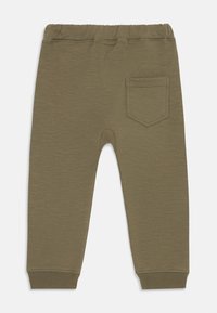 Un pantalon de survêtement vert olive avec une taille élastique et des poignets côtelés, comportant une petite poche arrière et un design simple et décontracté.