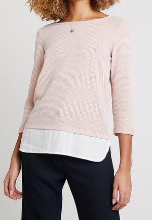 Lichtroze longsleeve met een gestructureerd patroon, gelaagd over een witte zoom. Ronde halslijn en een losse pasvorm. Geschikt voor casual draagstijl.