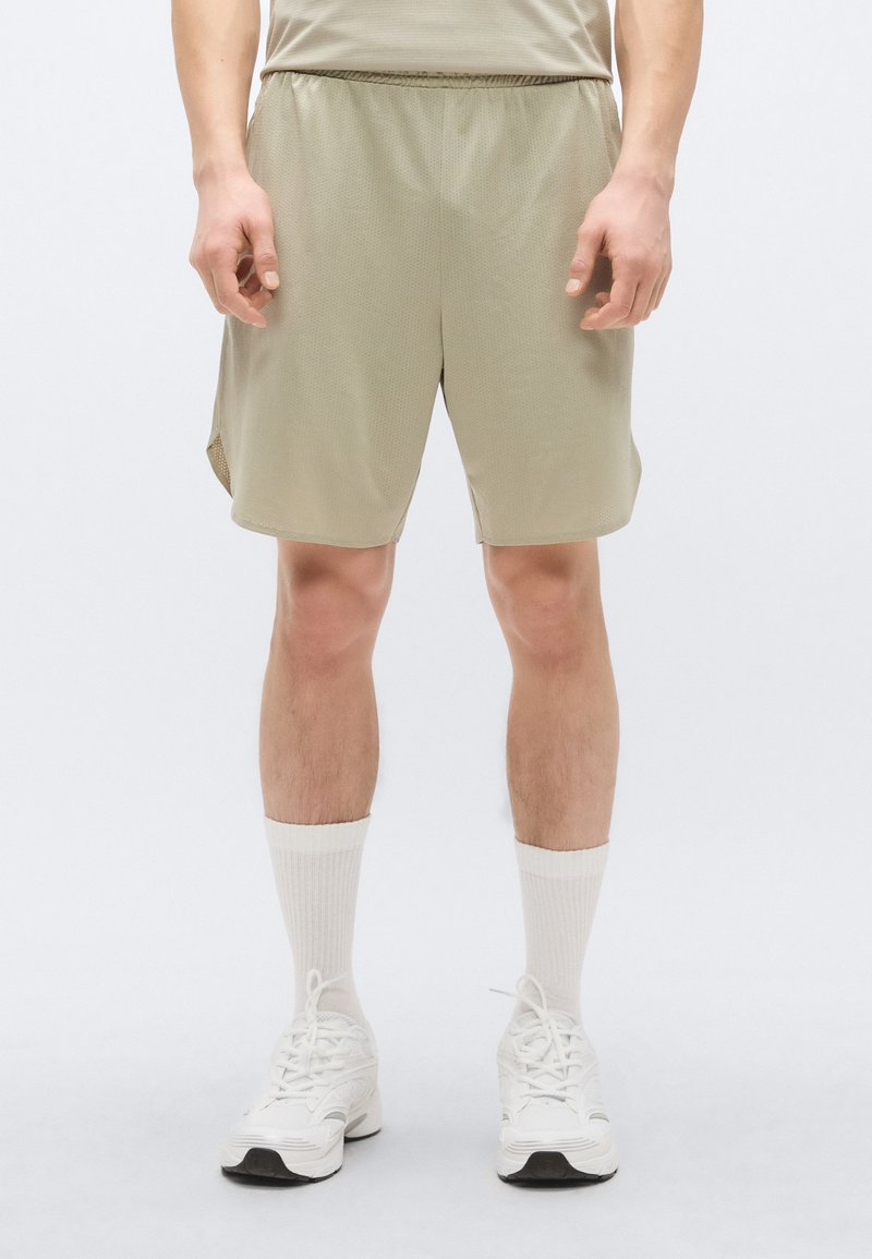Αθλητικά σορτς σε ανοιχτό ελιά χρώμα, κατασκευασμένα από διαπνέον ύφασμα δίχτυ, με σούρα στη μέση, πλαϊνές σχισμές και άνετη, φαρδιά γραμμή για άνεση.