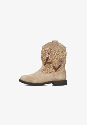 Beige Wildleder-Ankle-Boots mit strukturierten Wollakzenten, floralen Applikationen und bronzenen Nieten, flacher Sohle und dekorativen Nähten.