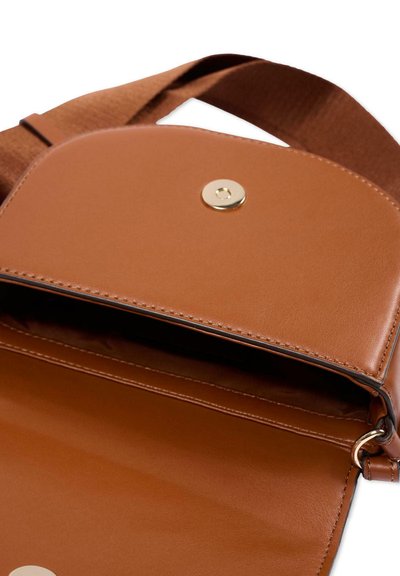 Bruine leren crossbodytas met klep en magnetische knoopsluiting, met zicht op het interieur en een textuur aanpasserbare riem.