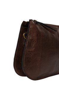 Borsa a pochette in pelle marrone con superficie strutturata, chiusura con cerniera sottile e tirazip in pelle. Presenta un accento in hardware color oro.