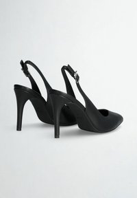 Tacchi alti neri a slingback con punta affusolata, texture in pelle liscia e tacco a stiletto sottile. Cinturino alla caviglia regolabile con finiture in argento.