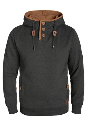Haut à capuche gris foncé avec un capuchon bordé de tan, patte de boutonnage à trois boutons et cordons de serrage. Dispose de poches latérales avec des accents en cuir. Matière en mélange de coton.