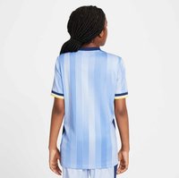 Hellblaues kurzärmliges Trikot mit vertikalen Streifen, navyfarbenen Akzenten und einem gelben Saum am Kragen und an den Ärmeln. Glatte Stoffstruktur.