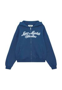 Felpa con zip di colore blu navy realizzata in tessuto morbido, dotata di cappuccio regolabile con cordino, due tasche frontali e ricamo bianco "Low Lights Studios".