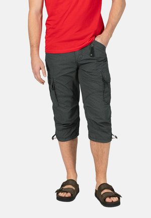 Dunkelgraue Cargo-Hosen mit einem strukturierten Muster, ausgestattet mit Seitentaschen und verstellbaren Bündchen, kombiniert mit braunen Sandalen und einem roten Shirt.