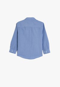 Camisa de manga larga a cuadros azul y blanco, con cuello puntiagudo, puños con botón y dobladillo curvado; hecha de una tela ligera.