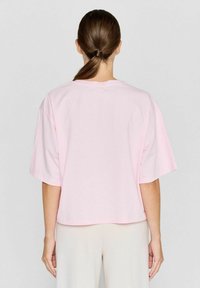 Roze katoenen t-shirt met korte mouwen en een losse pasvorm, voorzien van een ronde hals en een gladde, uniforme textuur. Achteraanzicht weergegeven.
