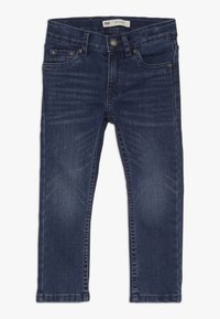 Jeans skinny de mezclilla azul oscuro con diseño de cinco bolsillos, cierre de cremallera y herrajes en tono plata. Presenta un ligero desvanecimiento y detalles de costura.