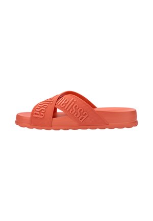 Des sandales en caoutchouc corail avec un bout ouvert, dotées de brides croisées embossées avec "Melissa" et d'une semelle texturée à motifs ondulés.