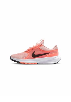 Zapatilla de running rosa claro y coral con el logo negro de Nike, parte superior de malla y suela blanca acolchada vista de lado sobre un fondo blanco.