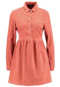 Korálový kordurový šaty s dlouhými rukávy, s límcem na knoflíky a nabraným pasem. Obsahuje řadu kovových knoflíků na přední straně.