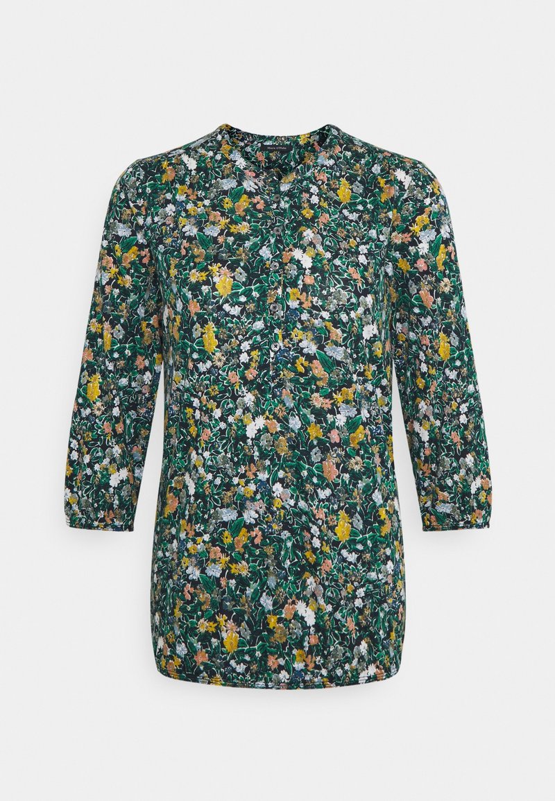 Blommig blus med trekvartslånga ärmar, med en mörkgrön bakgrund och ett mönster av gula, rosa och vita blommor. Rund halsringning.