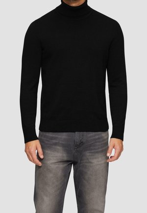 Schwarzer Rollkragenpullover aus weichem Strickmaterial mit langen Ärmeln und gerippten Bündchen, kombiniert mit hellgrauen Jeans mit verblasster Textur.