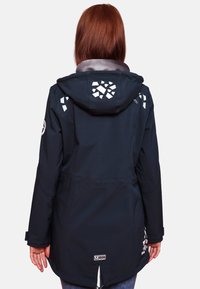 Waterproof navy jacket with a hood, featuring white reflective accents and geometric patterns on the back and shoulders. Soft texture, mid-length.