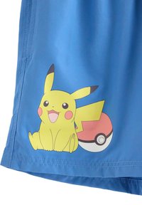 Μπλε υφασμάτινο μαγιό σορτς με ένα γραφικό του Pikachu που χαμογελά δίπλα σε μια Μπάλια Πόκε, με έμφαση σε έντονα χρώματα και παιχνιδιάρικο σχέδιο.