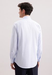 Camicia bianca con un motivo a griglia blu, maniche lunghe e orlo arrotondato, dotata di colletto standard e polsini con bottone.